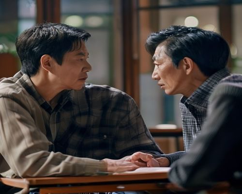 李采潭拍摄间隙与导演深度沟通剧本，神情专注认真，体现其专业态度